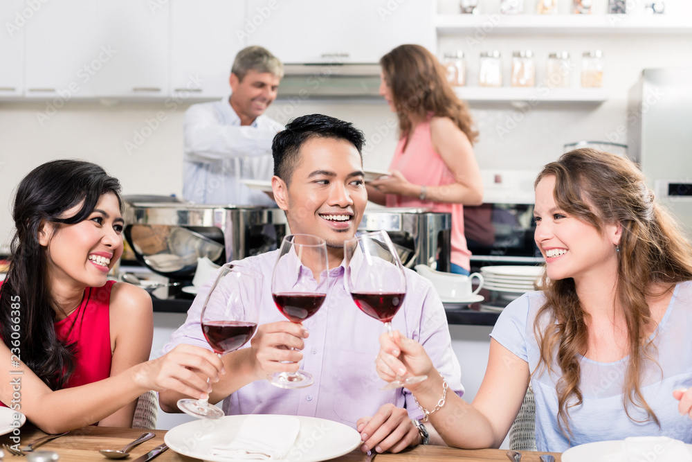 Fototapeta premium Group of friends holding red wine glass enjoying the party