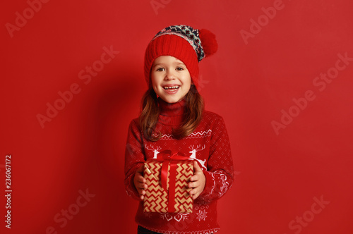 happy child girl with christmas gift over red