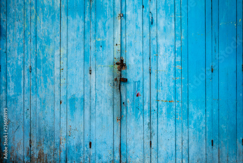 Old grunge and weathered blue wood door background and texture.
