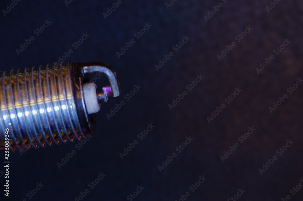 Car candle, principle of operation, blue spark. Macro.