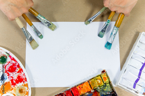 several paintbrushes with paint on a table