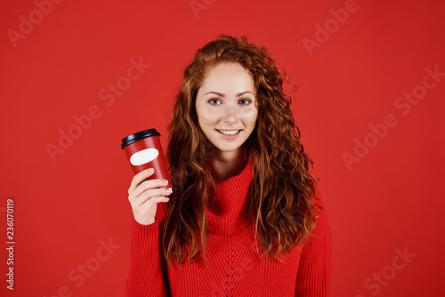 Portrait of smiling girl holding disposable mug of coffee