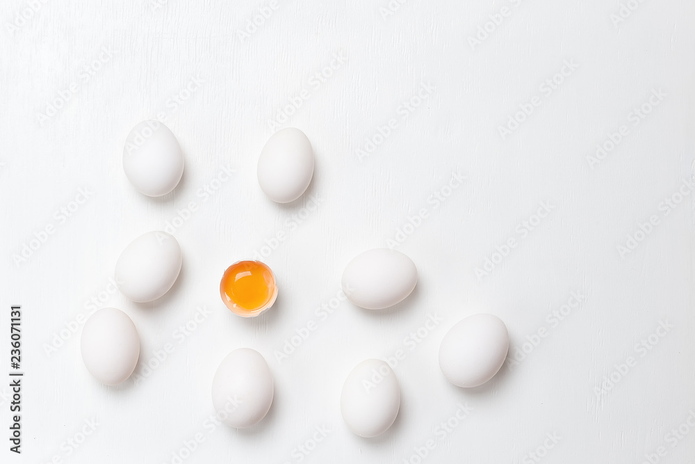 Eggs . One cracked and group of whole unheard eggs  on a white background.