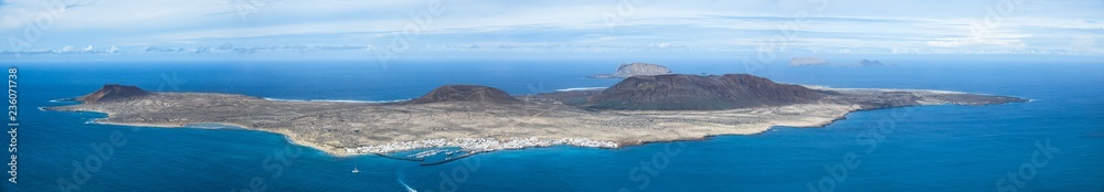 Caleta del Sebo, remote volcano island seen from a viewpoint on the north of Lanzarote, Canary Islands. Panorama background.