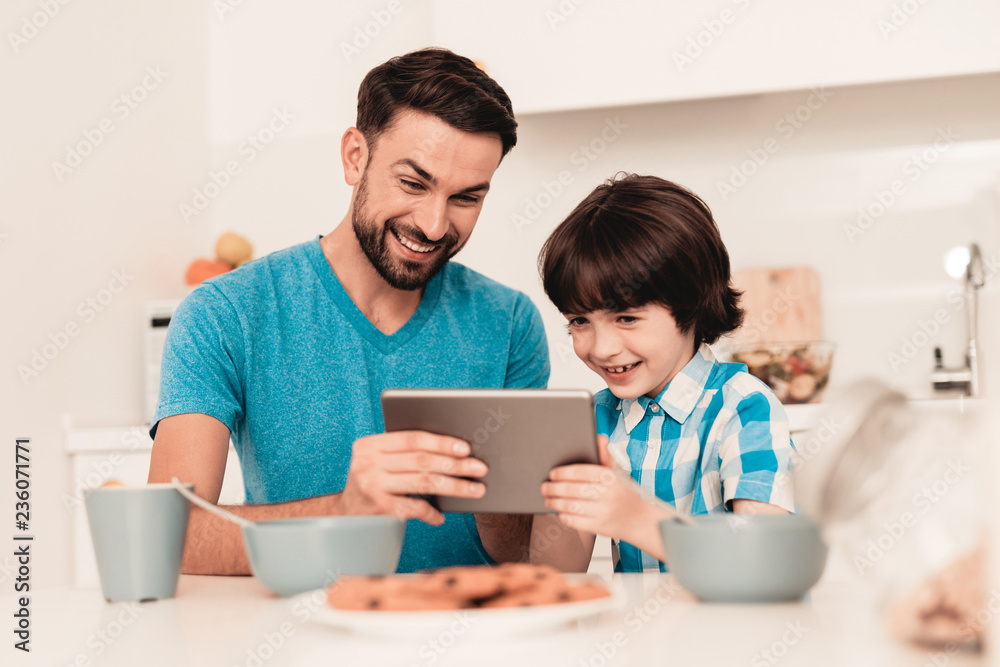 Happy Young Father and Son Using Tablet at Home.