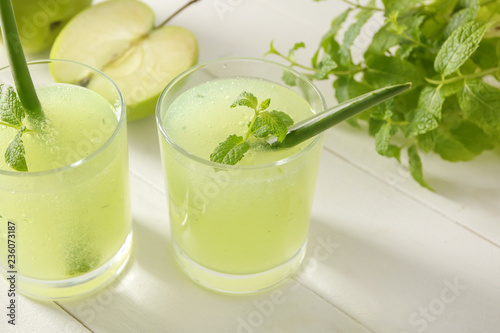 Glasses of healthy aloe cocktail on white table