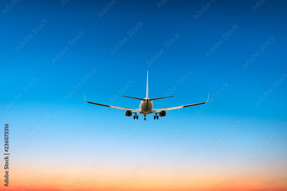 Fototapeta premium Airplane flying above dramatic clouds during sunset