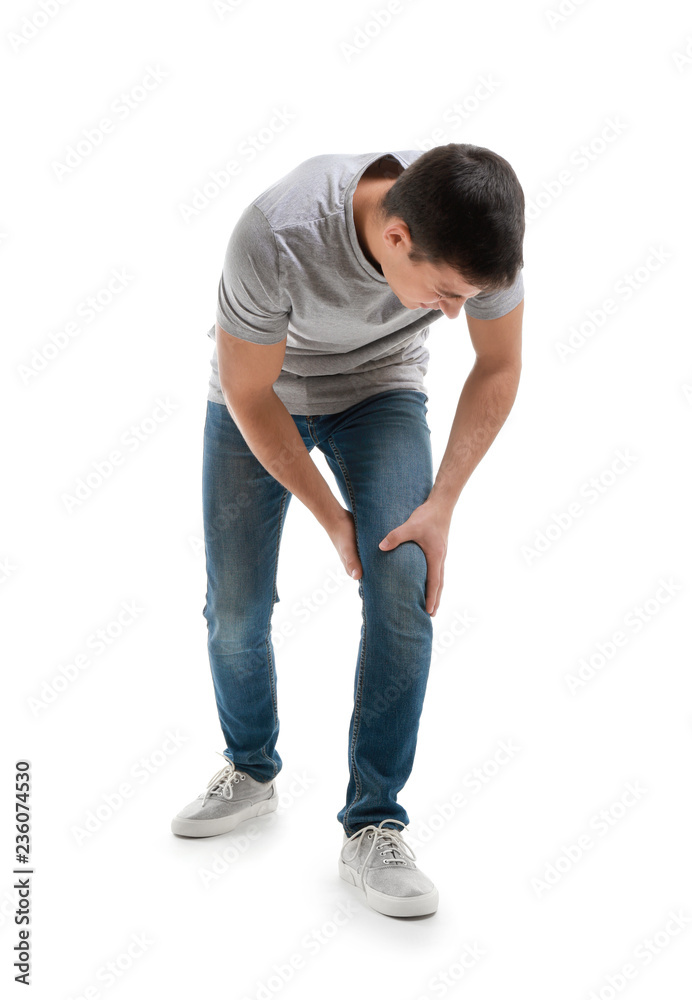 Young man suffering from pain in knee on white background Young man suffering from pain in knee on white background