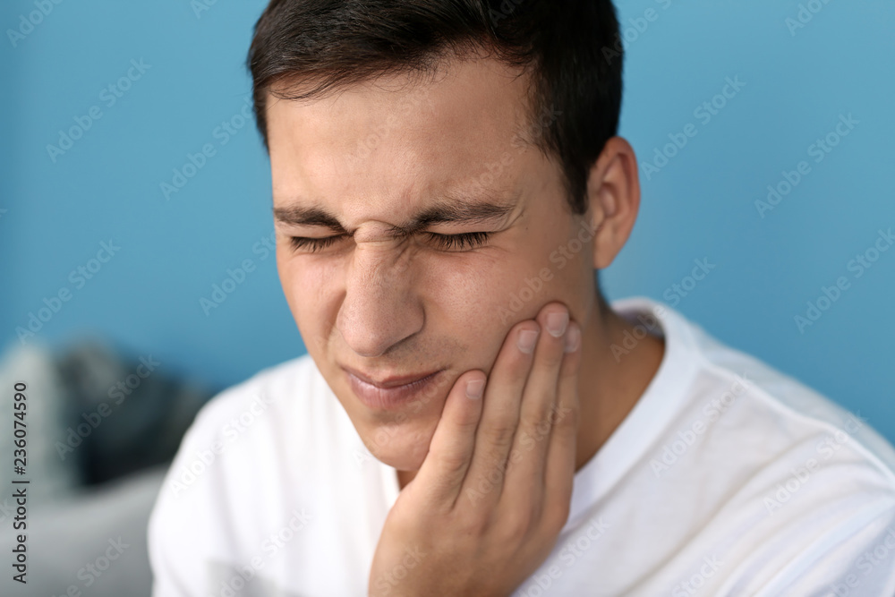 Young man suffering from toothache at home Young man suffering from toothache at home