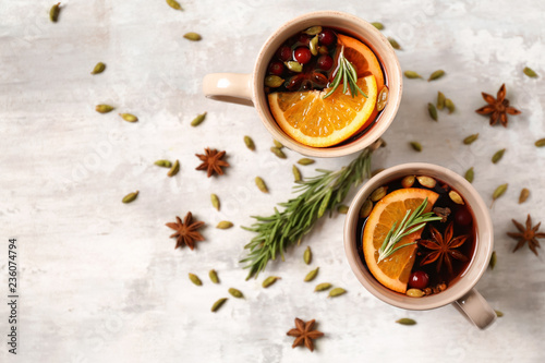 Cups of tasty mulled wine on light background