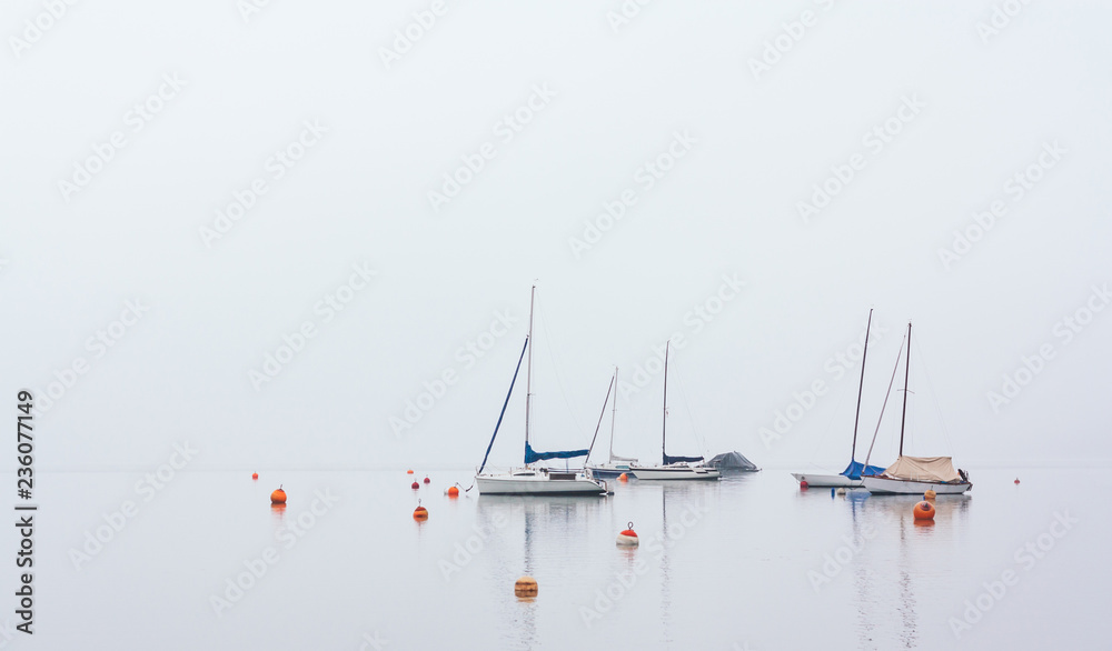 Isolated boats in fog at Wolfgangsee, Austria