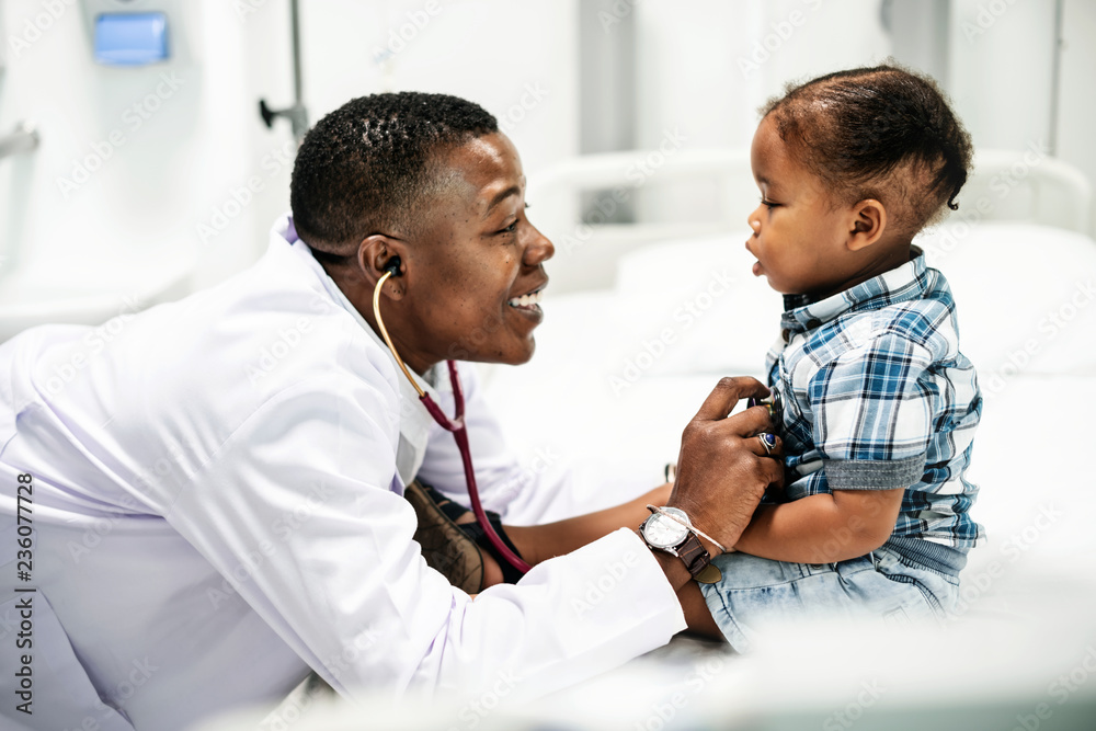 Cheerful pediatrician doing a medical checkup of a young boy Cheerful pediatrician doing a medical checkup of a young boy