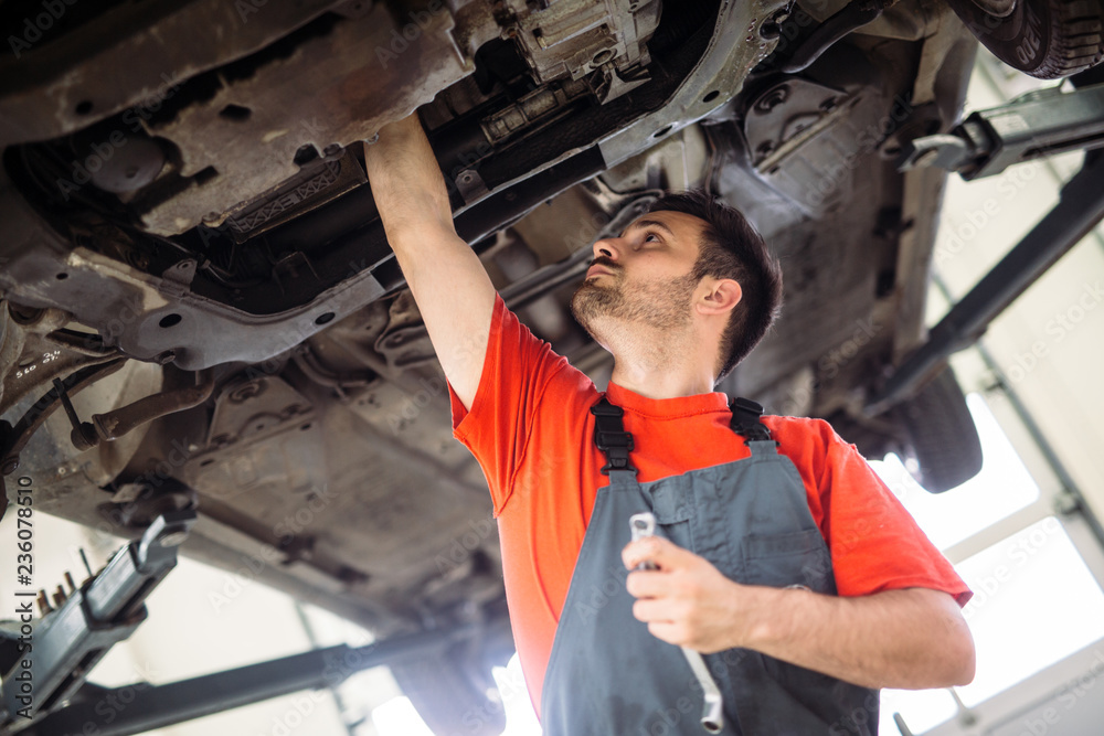 Car mechanic working at automotive service center Car mechanic working at automotive service center