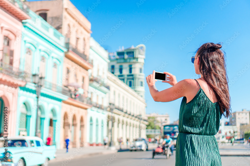 Tourist girl in popular area in Havana, Cuba. Young woman traveler smiling happy.