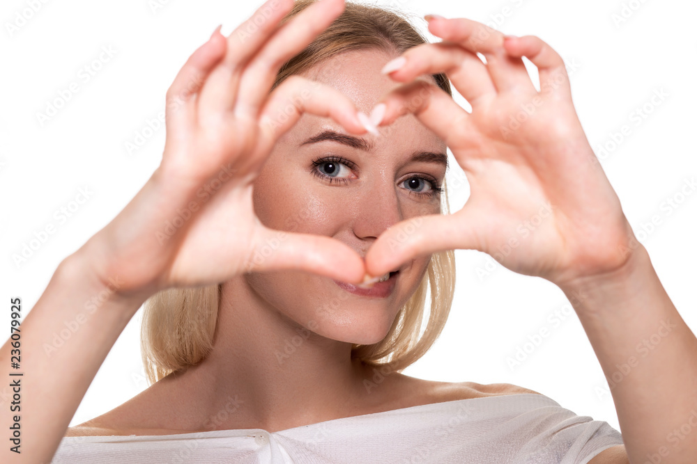 Fototapeta premium Portrait smiling young woman making heart sign with hands