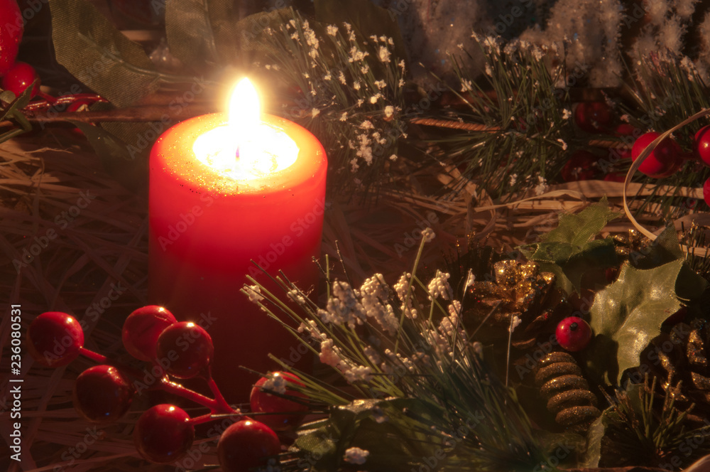Candella natalizia. Luce soffusa della candela natalizia con decorazioni ed  ornamenti sullo sfondo. Atmosfera di Natale. Stock Photo