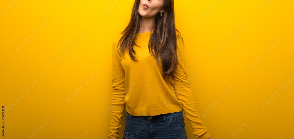 Teenager girl on vibrant yellow background makes funny and crazy face emotion Teenager girl on vibrant yellow background makes funny and crazy face emotion