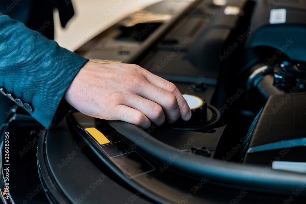 cropped image of businessman checking car hood of automobile cropped image of businessman checking car hood of automobile