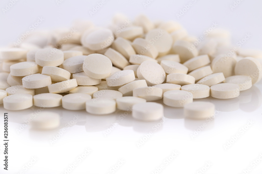 Close-up pile of white color medical pills on white background Close-up pile of white color medical pills on white background