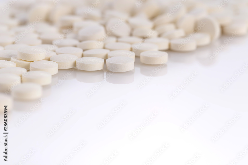 Close-up pile of white color medical pills on white background