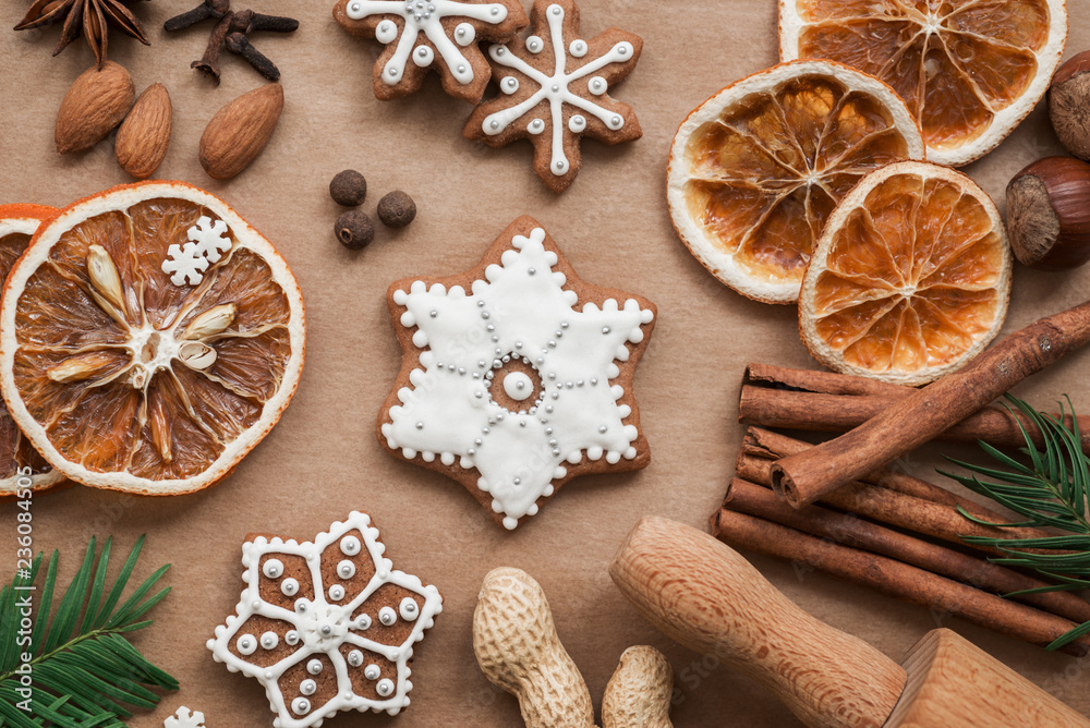 Frame with fir branches, Gingerbread cookies and Christmas decorations on dark brown paper background. Top view. Frame with fir branches, Gingerbread cookies and Christmas decorations on dark brown paper background. Top view.