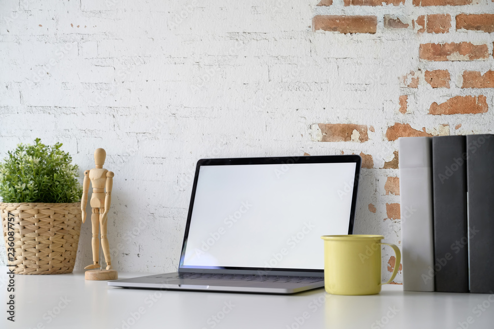 Fototapeta Makieta laptopa pokazano pusty ekran na białym biurku obszaru roboczego.