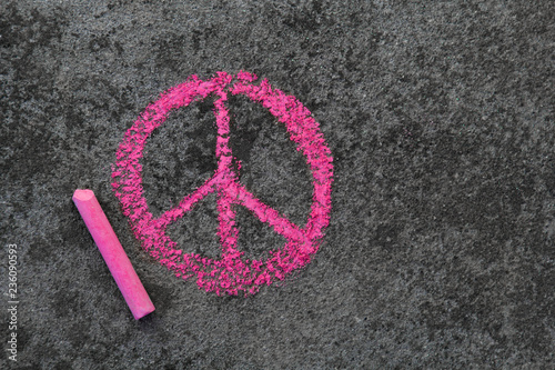 Colorful chalk drawing on sidewalk: Pink peace symbol