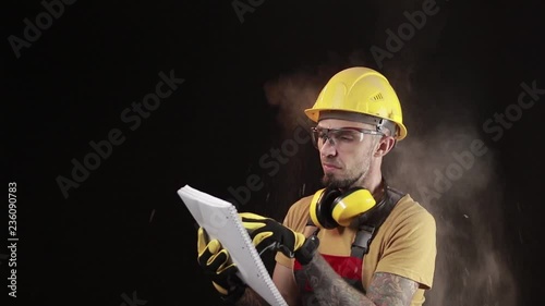 A brick falling from height towards a workers head which. Work safety concept with hard hat, protective gloves, eye safety glasses and hearing protection