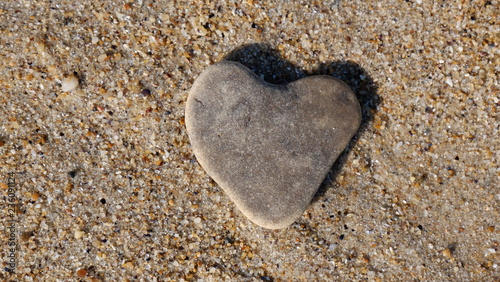 Stone in the form of a heart in the sand, as a symbol of love.