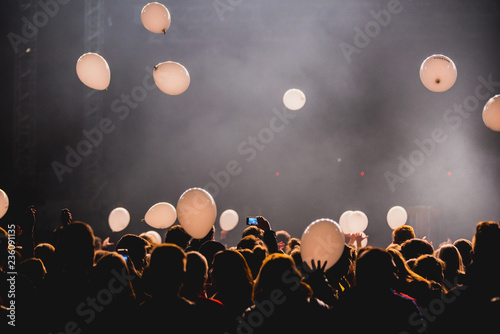 Crowd at concert, balloons in the air.