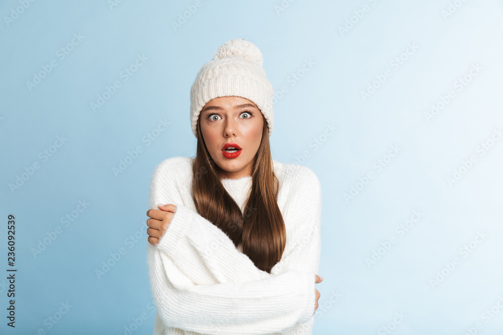 Obraz premium Frozen young woman wearing hat and sweater standing