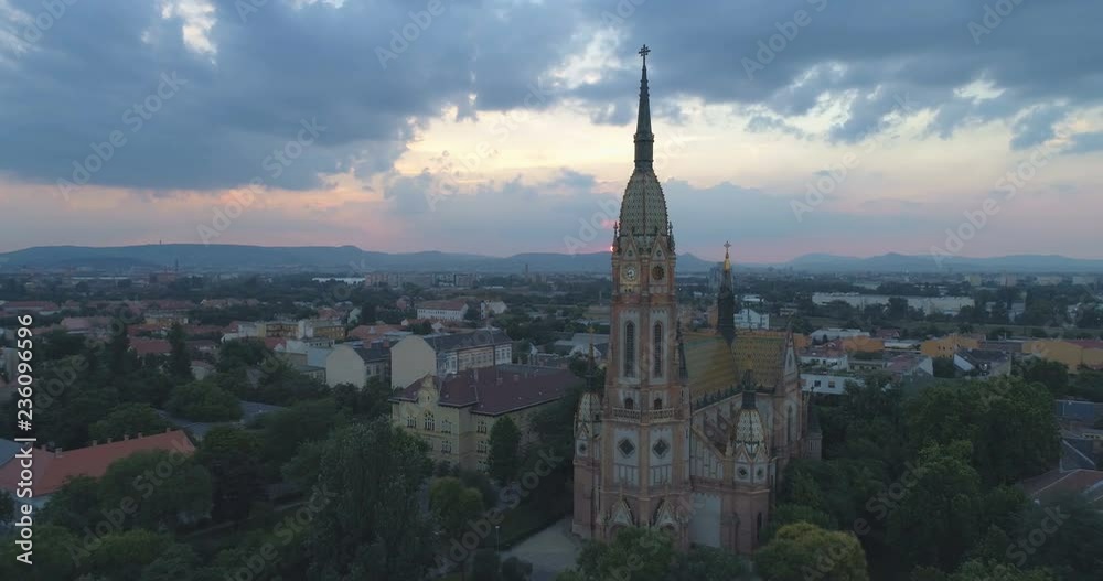 Aerial shot of catholic church in Budapest at sunset with cityscape and sun in view Aerial shot of catholic church in Budapest at sunset with cityscape and sun in view