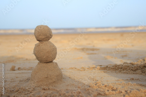 Tableau sur toile Sand snowman for those who celebrate New Year by the sea or ocean