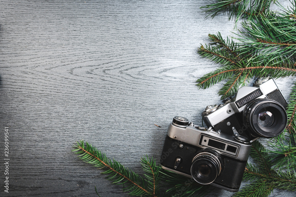 Top View of Vintage Camera Between Christmas tree, on Wooden Texture, copy space - obrazy, fototapety, plakaty 