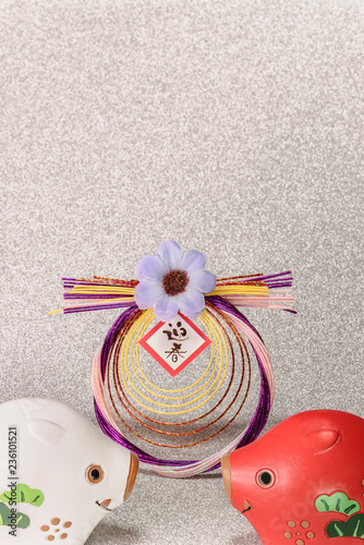 Japanese New Year's Cards with black handwriting ideograms Geishun which means Welcoming Spring with cute Zodiac animals figurines of two boars and ornament flower on a glitter silver background. photo