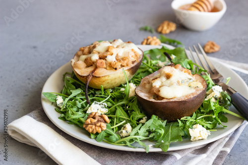 Baked pears with gorgonzola, chicken, walnuts and mozzarella with arugula on a grey plate. Grey slate, stone or concrete table. Healthy salad or snack for Christmas or New Year. Copy space.