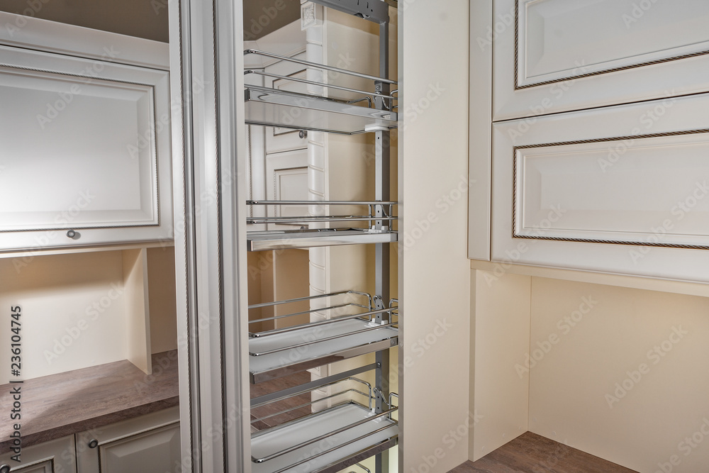 Close Up home interior. Kitchen - opened door with chrome furniture shelf. Wood and Chrome Material, Modern Design. Close Up home interior. Kitchen - opened door with chrome furniture shelf. Wood and Chrome Material, Modern Design.