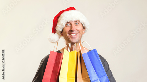 Online shopping christmas. New year gifts. Happy Santa with shopping bags, isolated on white. Copy space. Christmas shopping, sales and discounts concept. Man in christmas hat enjoying shopping.