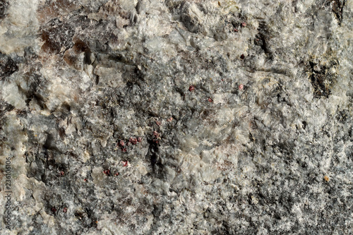 The structure of natural non-polished granite of gray color. Natural background  cropped shot  close-up. The concept of nature and production.