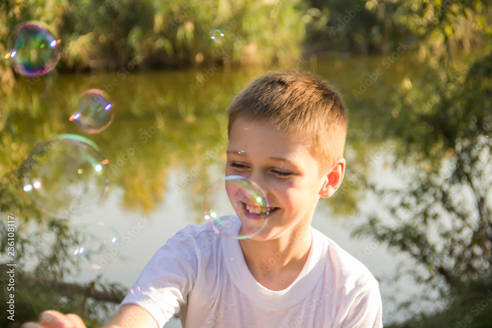 The boy inflates soap bubbles in nature The boy inflates soap bubbles in nature