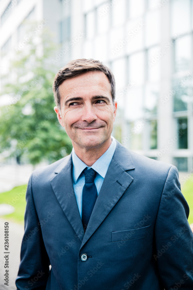 Portrait of smiling businessman in the city looking sideways Portrait of smiling businessman in the city looking sideways