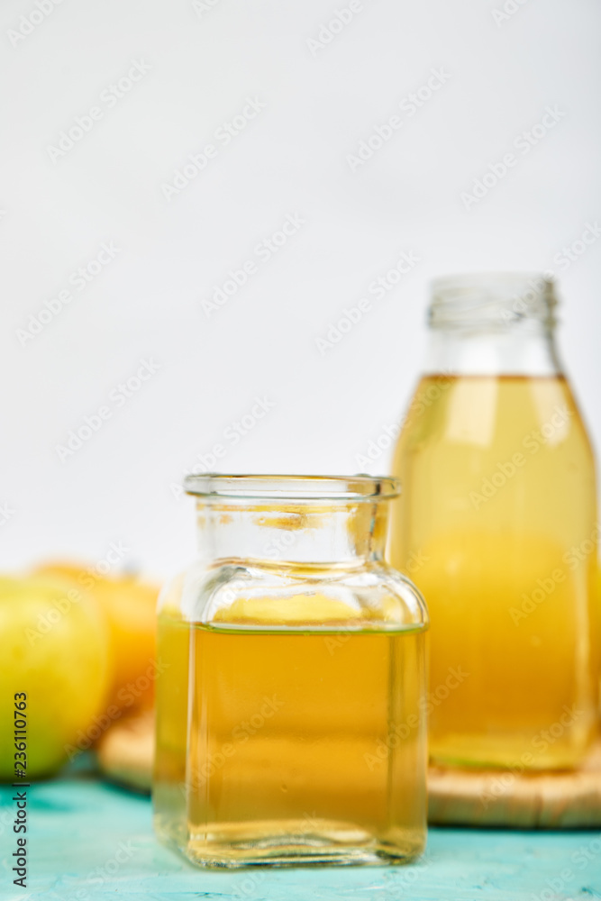 Glass Bottle of apple organic vinegar on blue background. Glass Bottle of apple organic vinegar on blue background.