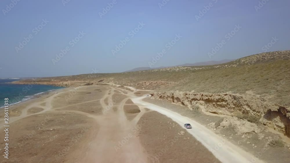 Cars driving on wild sandy beach along coast, aerial shot Cars driving on wild sandy beach along coast, aerial shot