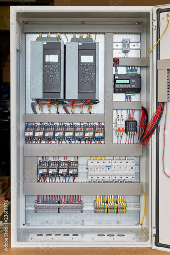 Electrical Cabinet with frequency converters, controller, circuit breaker. On the mounting panel mounted thermostat, intermediate relays and fuse holders. The wires are laid in cable channels.