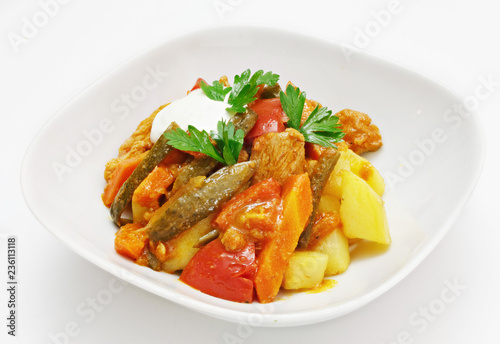Dish of vegetables and meat on a white background