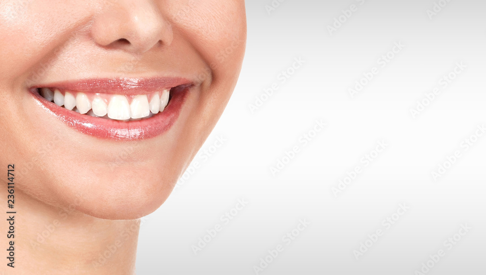 Obraz premium Pretty woman smile against a grey background with copyspace
