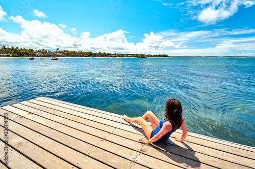 beautiful woman relaxing on jetty beside belle mare beach, mauritius island