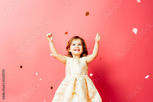 Studio shot of toddler girl throwing confetti