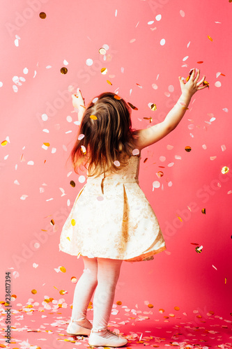 Studio shot of toddler girl throwing confetti
