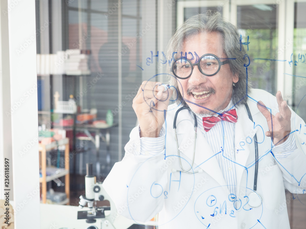 asian scientist writes a formula on a glass Board asian scientist writes a formula on a glass Board